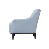 Side profile of light blue tufted armchair.
