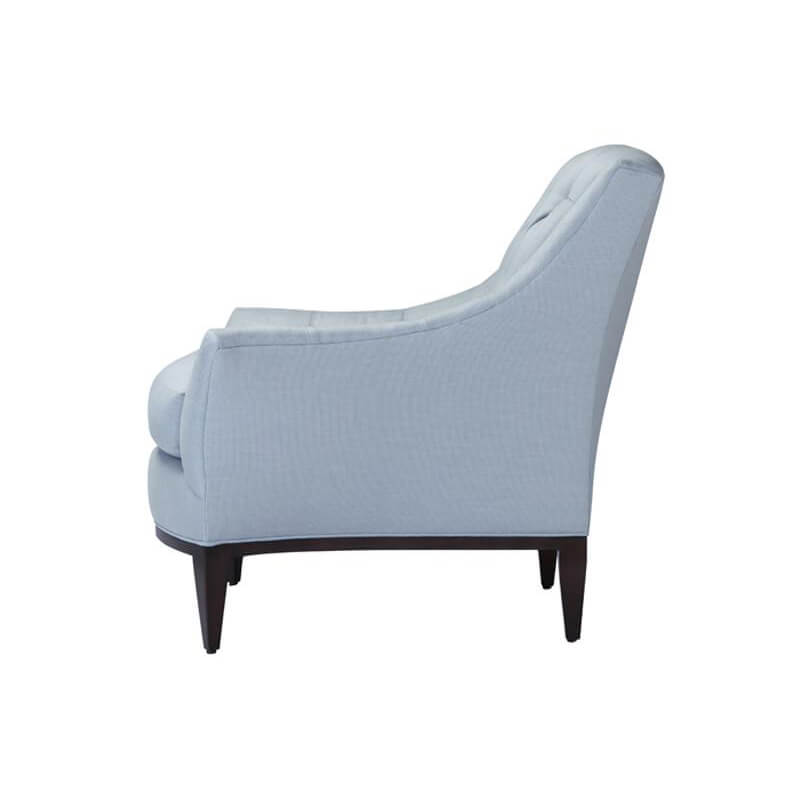 Side profile of light blue tufted armchair.