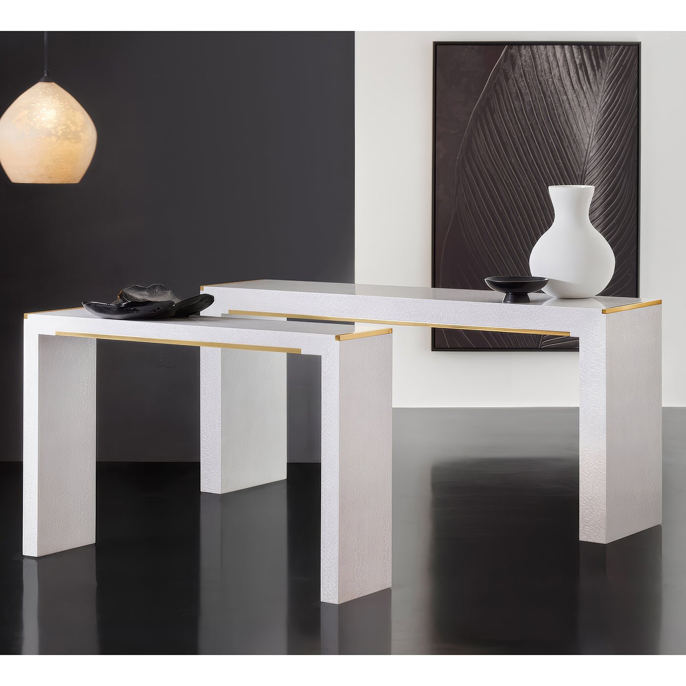 Two white console tables with gold accents in modern room.