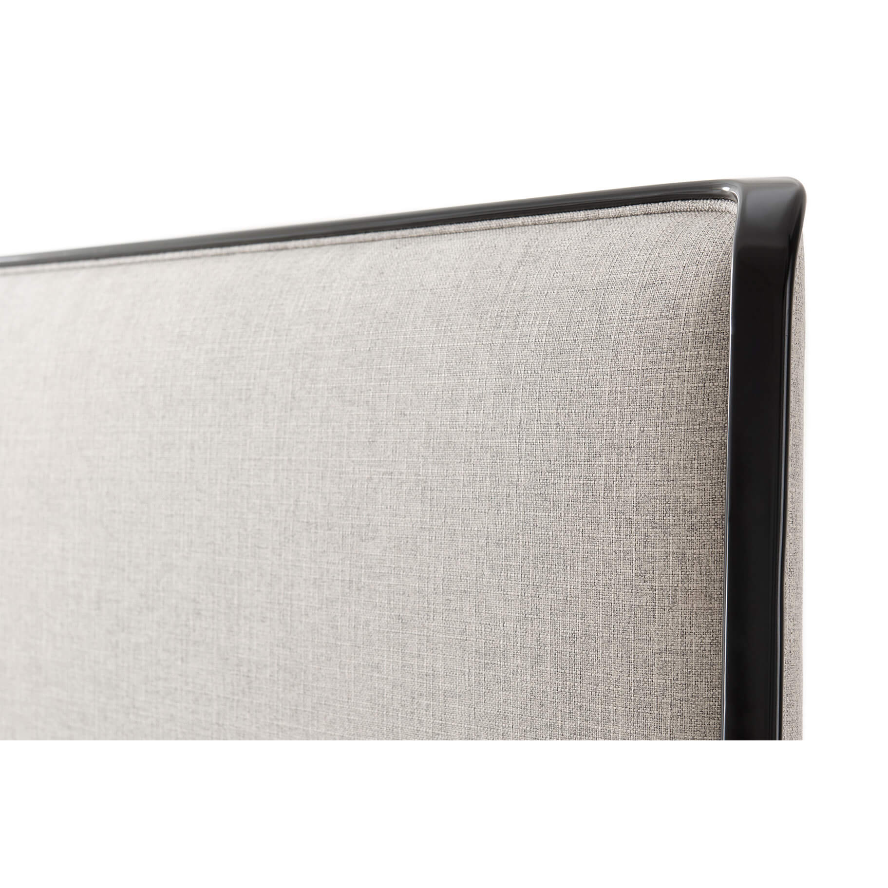 Close-up of beige headboard with black trim.