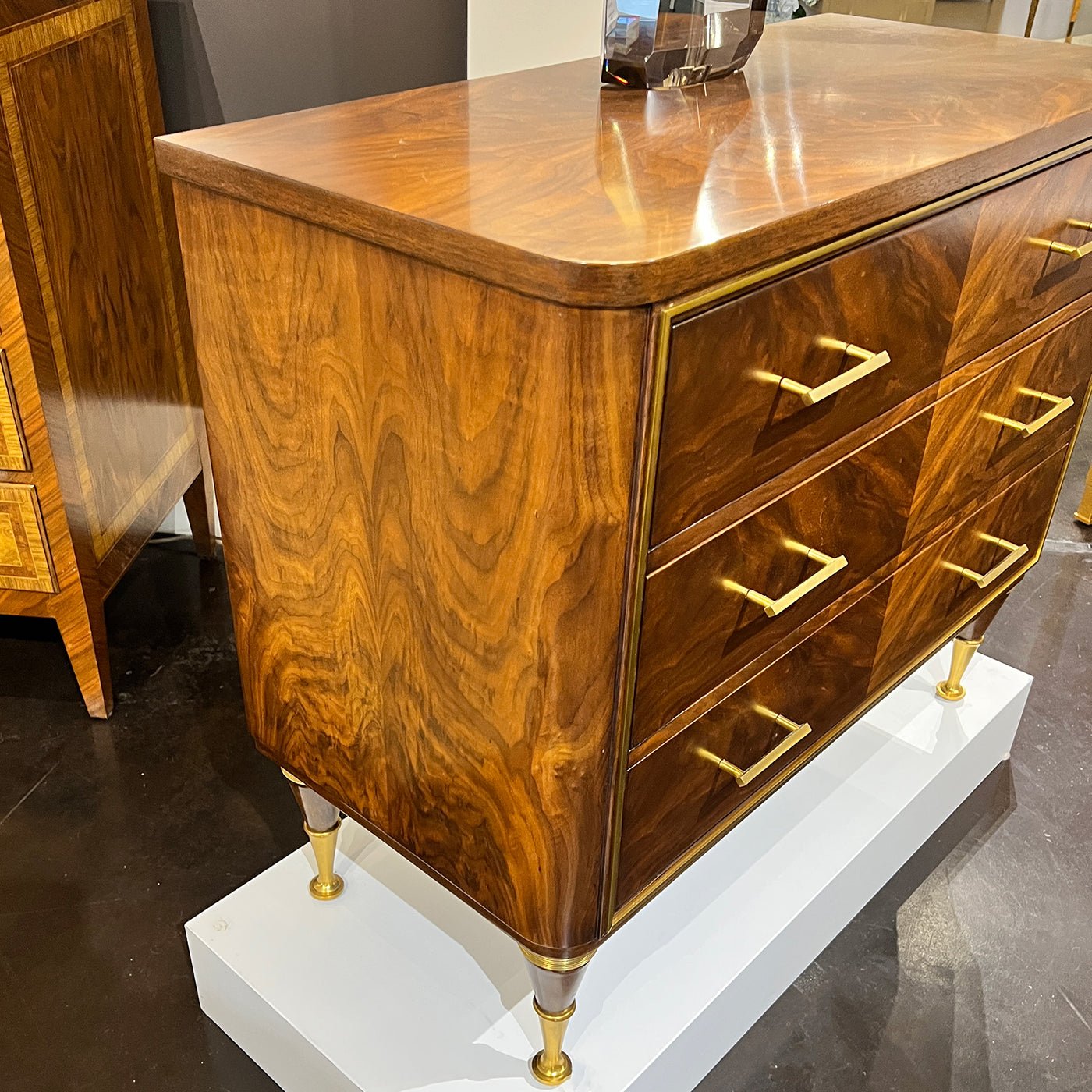 Side view of walnut bedside chest, gold accents.