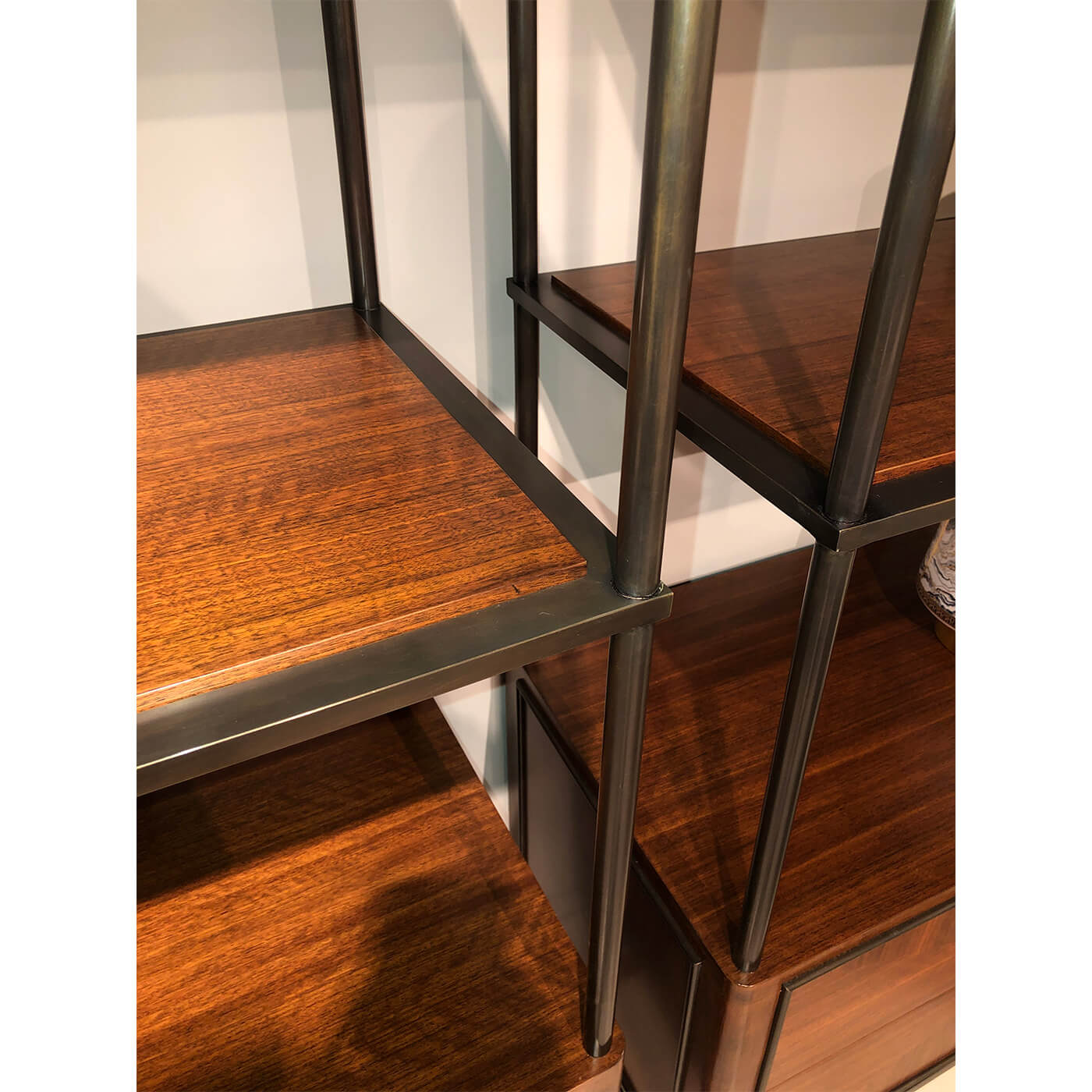 Metal frame detail of mid-century walnut etagere shelves.