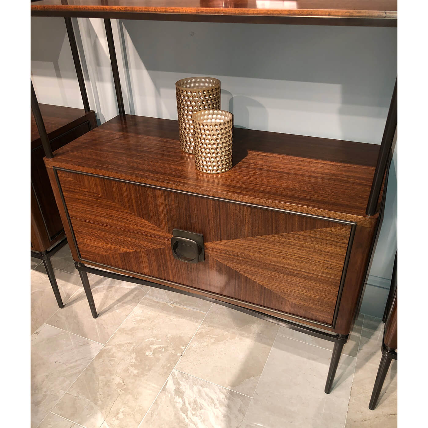 Decor items on walnut etagere in interior setting.