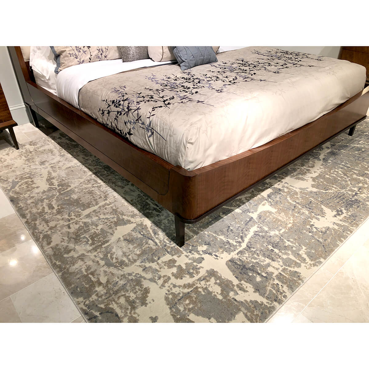 Lower bed view, patterned rug and walnut bed.