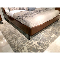 Lower bed view, patterned rug and walnut bed.