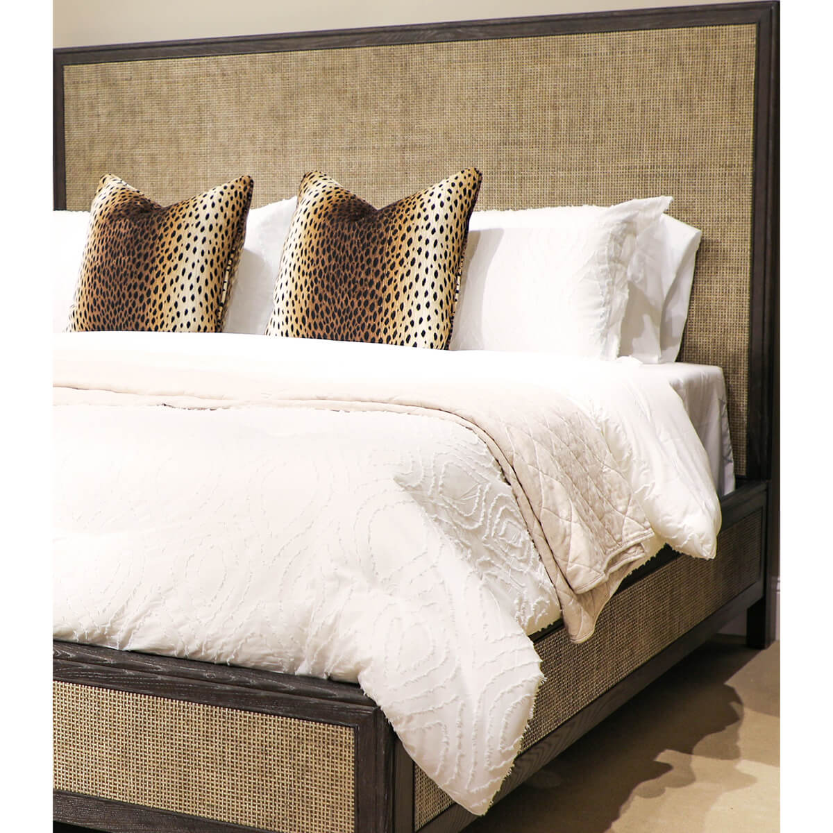 Close-up of modern bed with white bedding, decorative pillows.