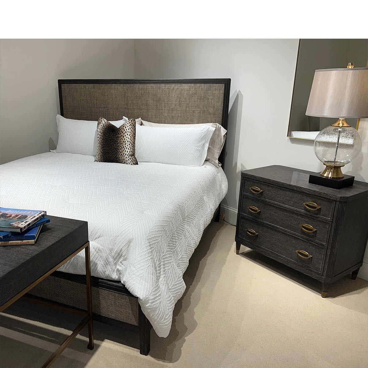 Modern bed with gray headboard, white bedding, nearby nightstand.
