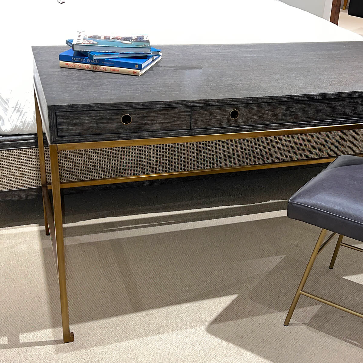 Close-up of desk with books, gray and gold detailing.