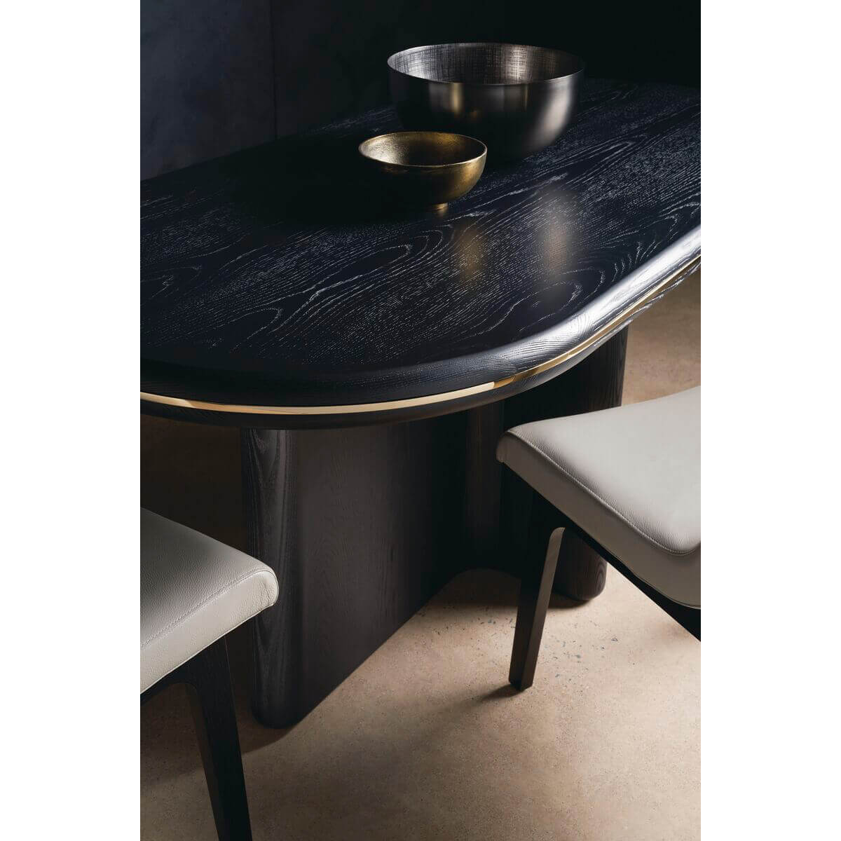 Black dining table close-up with bowls and chairs.