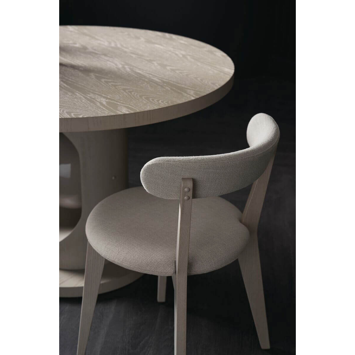 Minimal oak dining chair at round table setting.