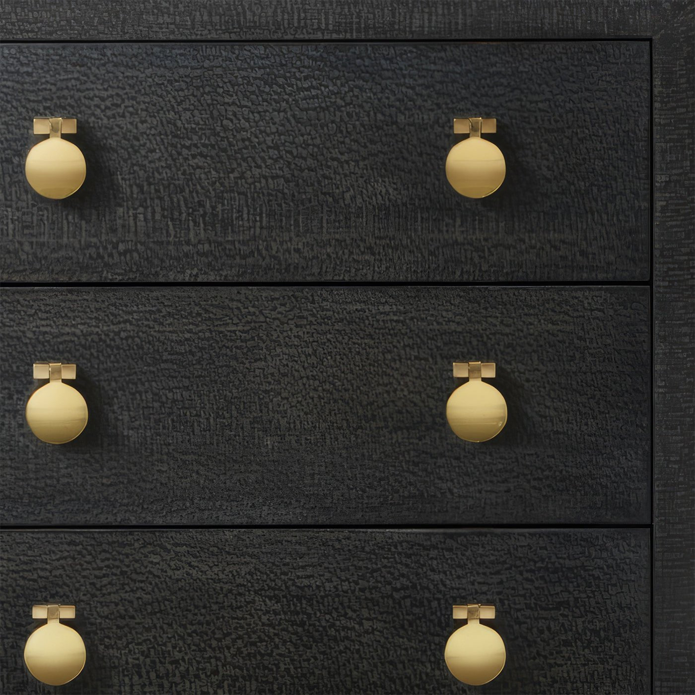Close-up of modern black chest with gold knobs.