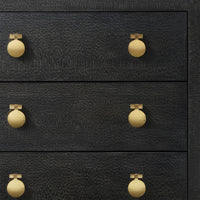 Close-up of modern black chest with gold knobs.