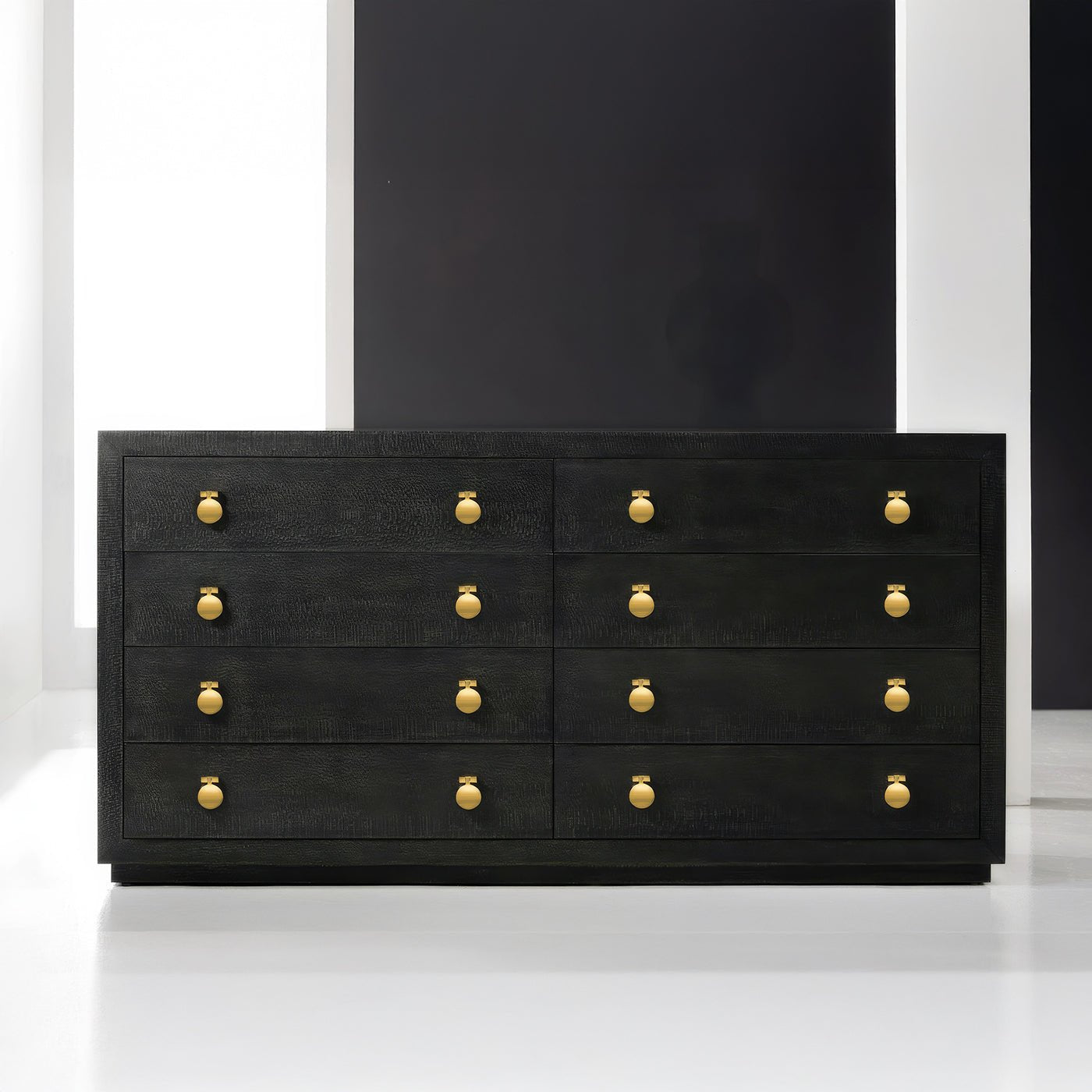 Black dresser with gold knobs, in sleek modern setting.