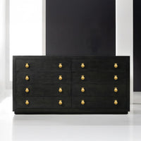 Black dresser with gold knobs, in sleek modern setting.