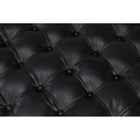 Close-up of tufted black leather surface.