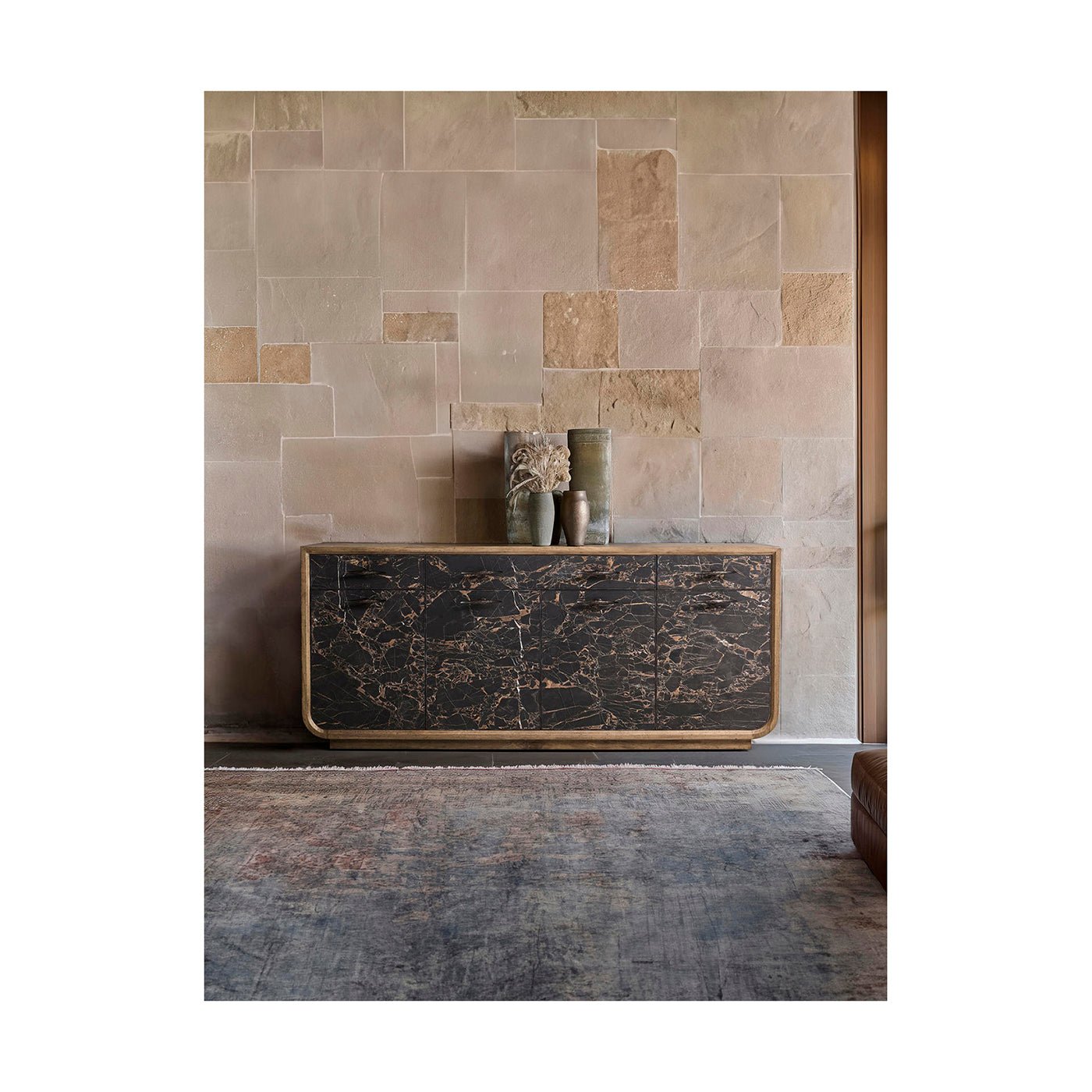 Sideboard against stone wall setting in room.