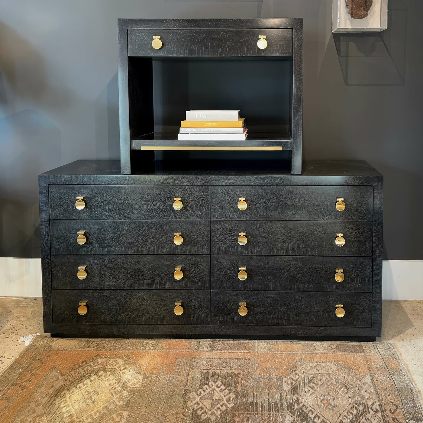 Modern black nightstand on dresser with books.