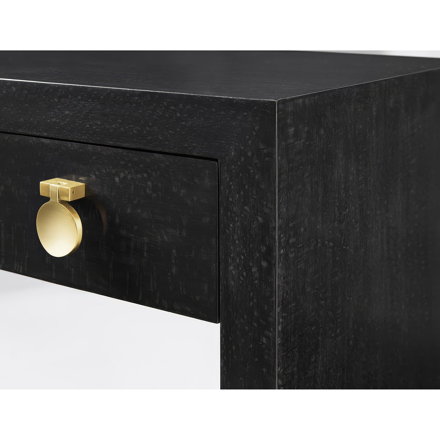 Close-up of black nightstand's gold drawer handle.