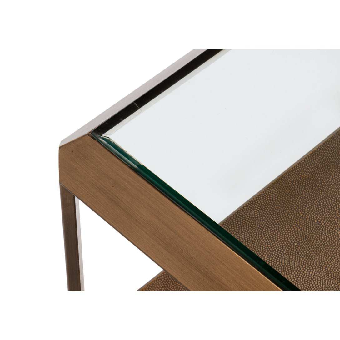 Close-up of coffee table corner, brass and glass.