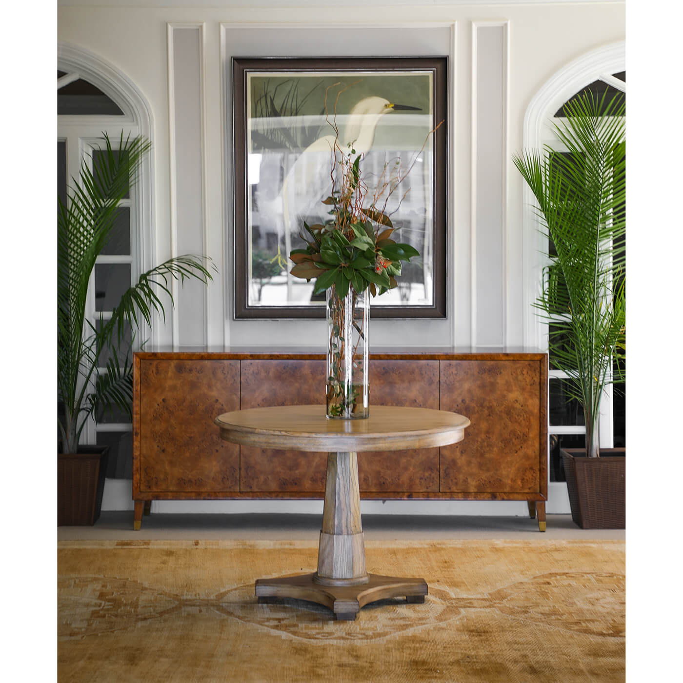 Burl sideboard behind a round table in a stylish room.