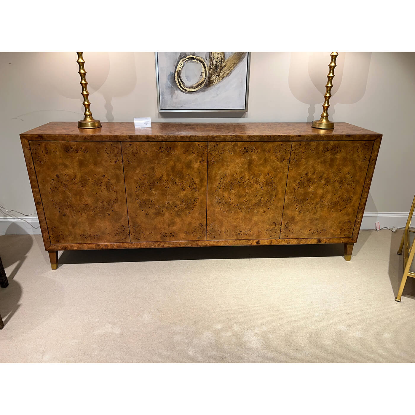 Burl sideboard with table lamps and wall art.