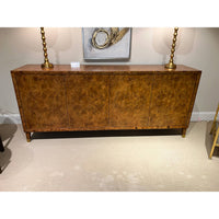 Burl sideboard with table lamps and wall art.