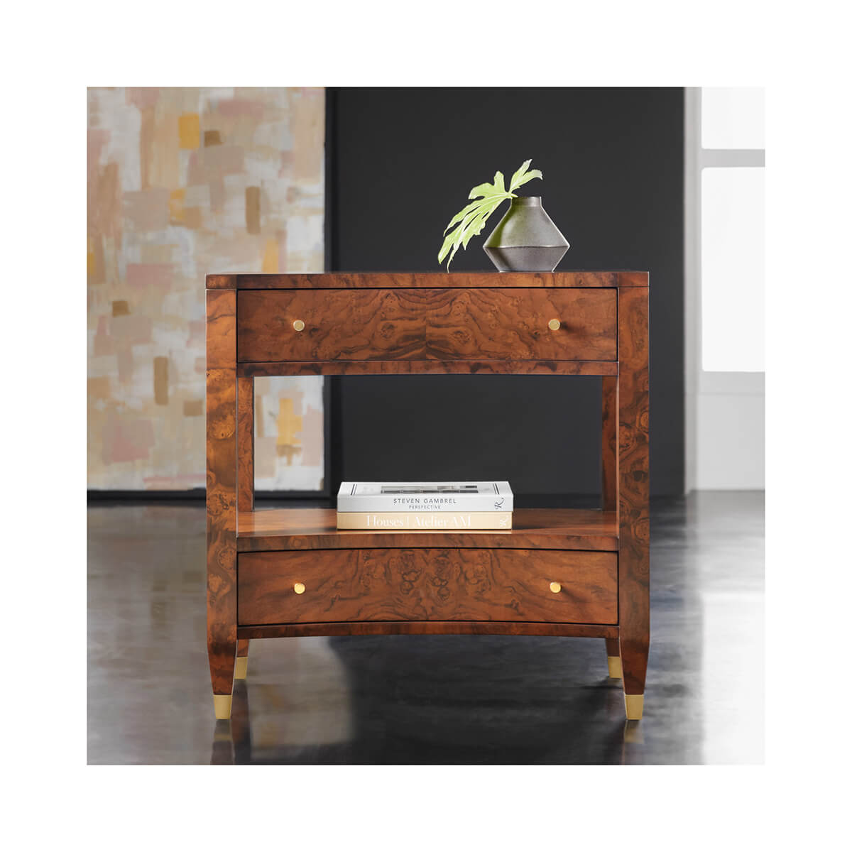Decorated nightstand with books and plant, modern design.