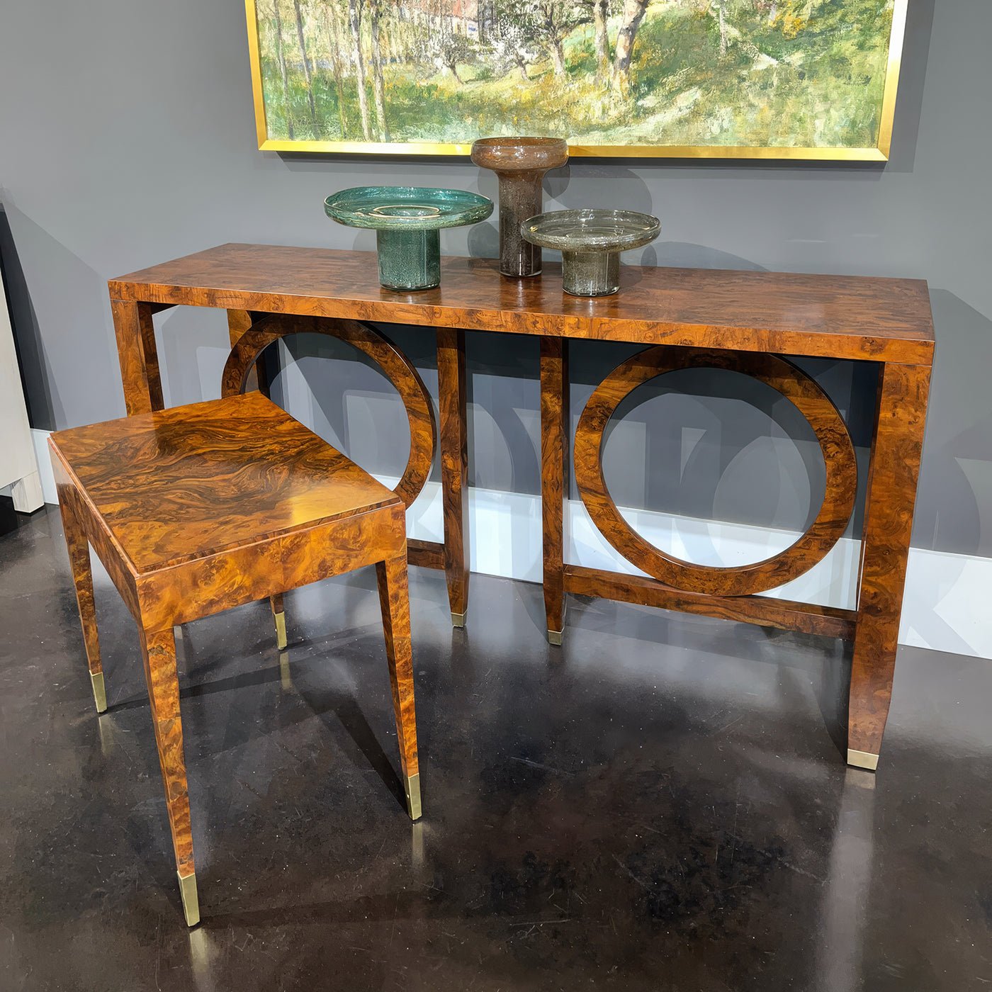 Console table with decor and matching stool in room.
