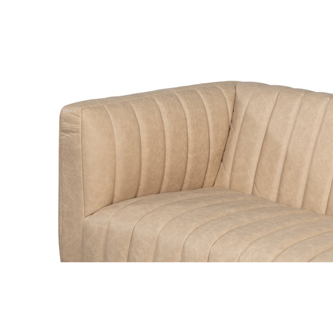 Close-up of sofa corner, tufted white leather detail.