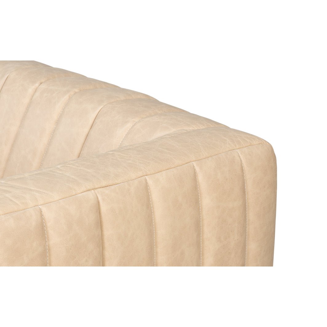 Upper corner tufting detail on modern white leather sofa.