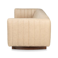 Side view of modern tufted white leather sofa.