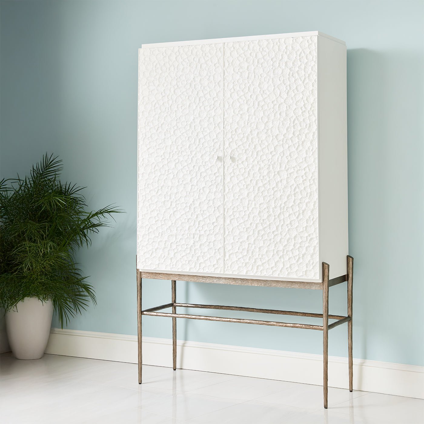 Closed bar cabinet against a light blue wall.