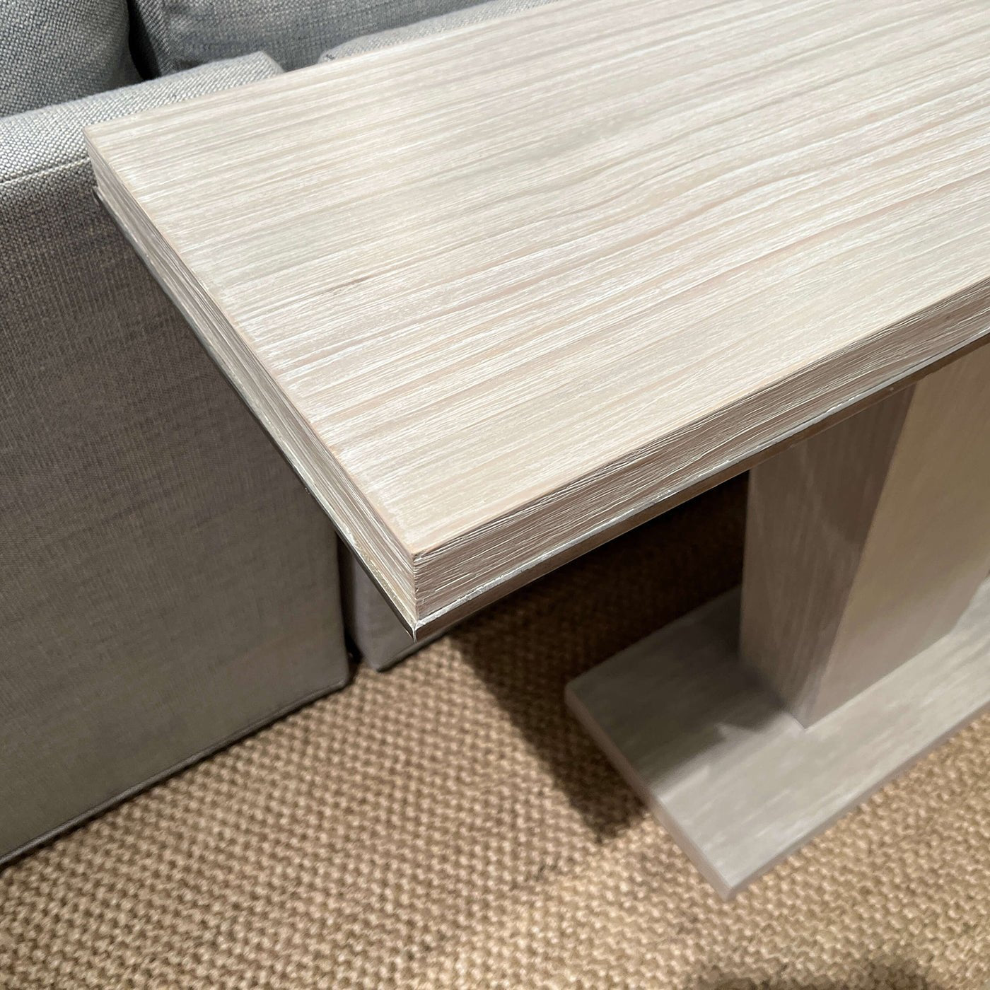 Modern coastal console table next to sofa, end detail.
