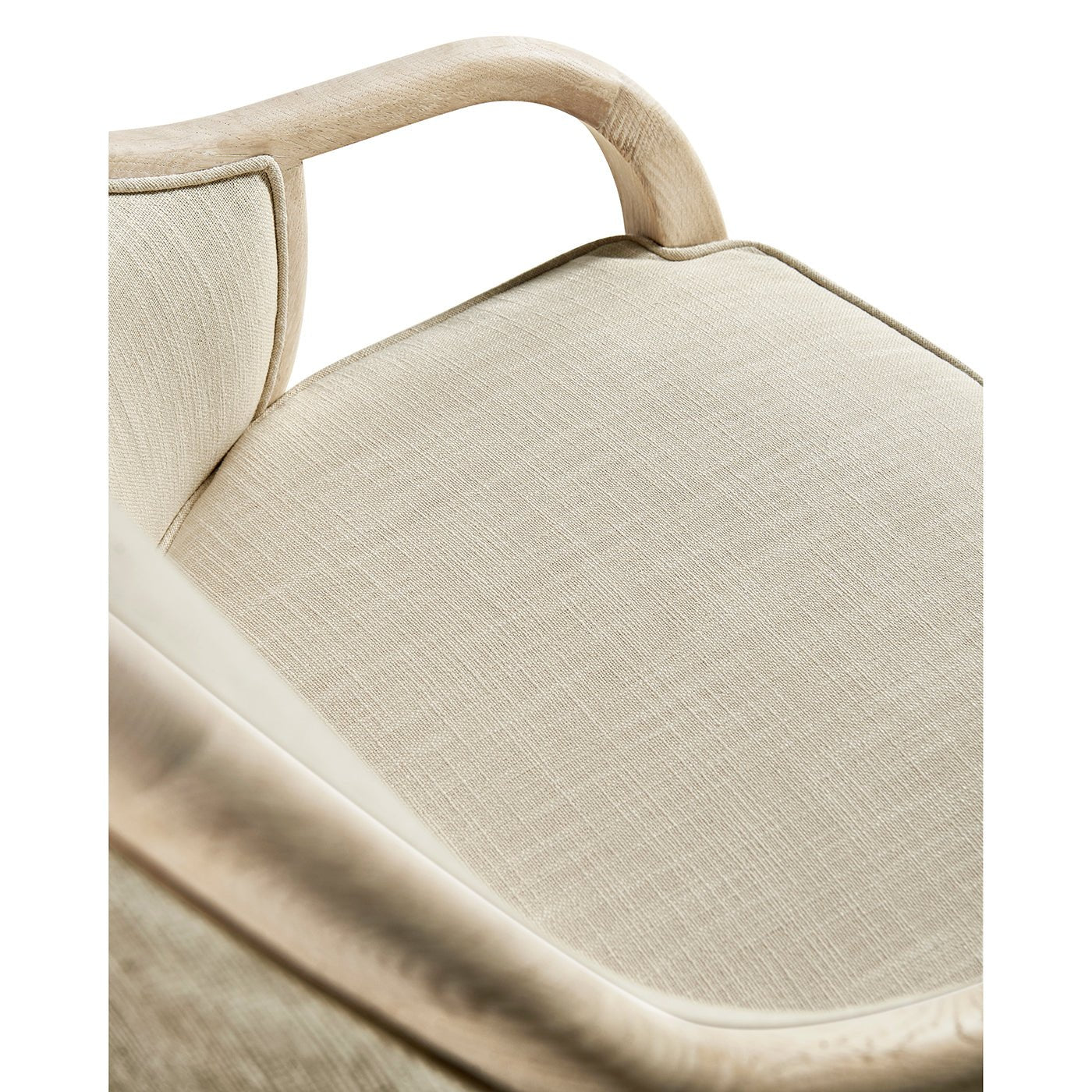 Close-up of armchair seat cushion detail and armrest.