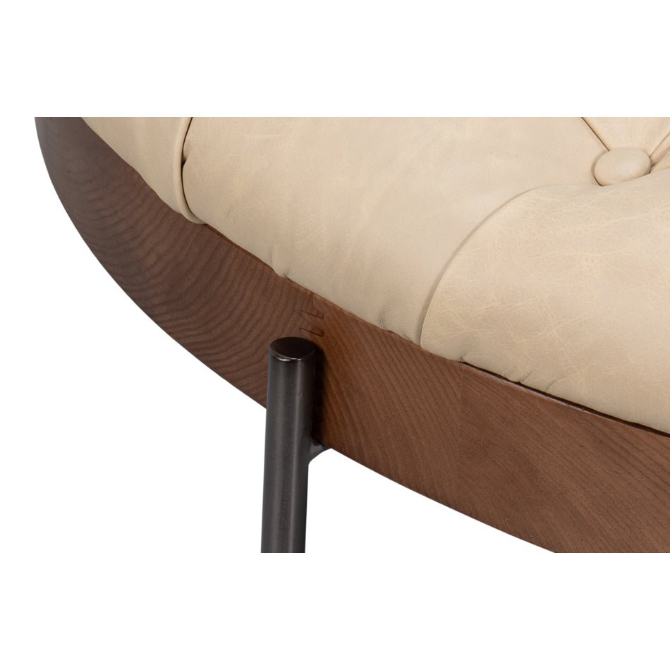Detailed look at ottoman's wooden frame and upholstery.