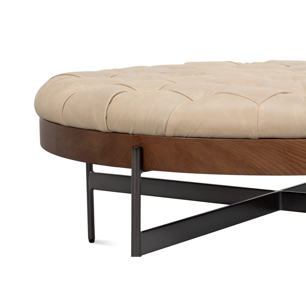 Angle view showcasing ottoman's tufted leather surface.
