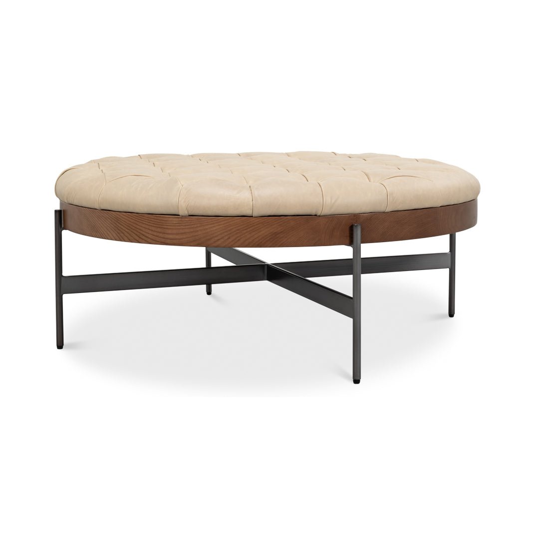 Close angle of ottoman emphasizing wooden frame and legs.