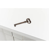 Antique-style key on white painted sideboard surface.