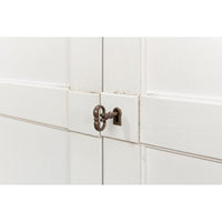 Close-up of keyhole on white sideboard.