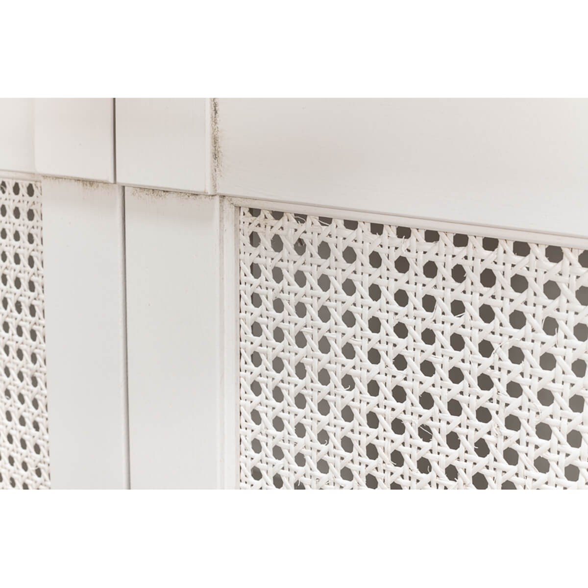 Close-up lattice detailing on white sideboard.
