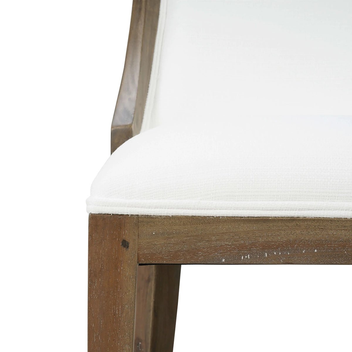 Close-up of dining chair seat edge, white upholstery.