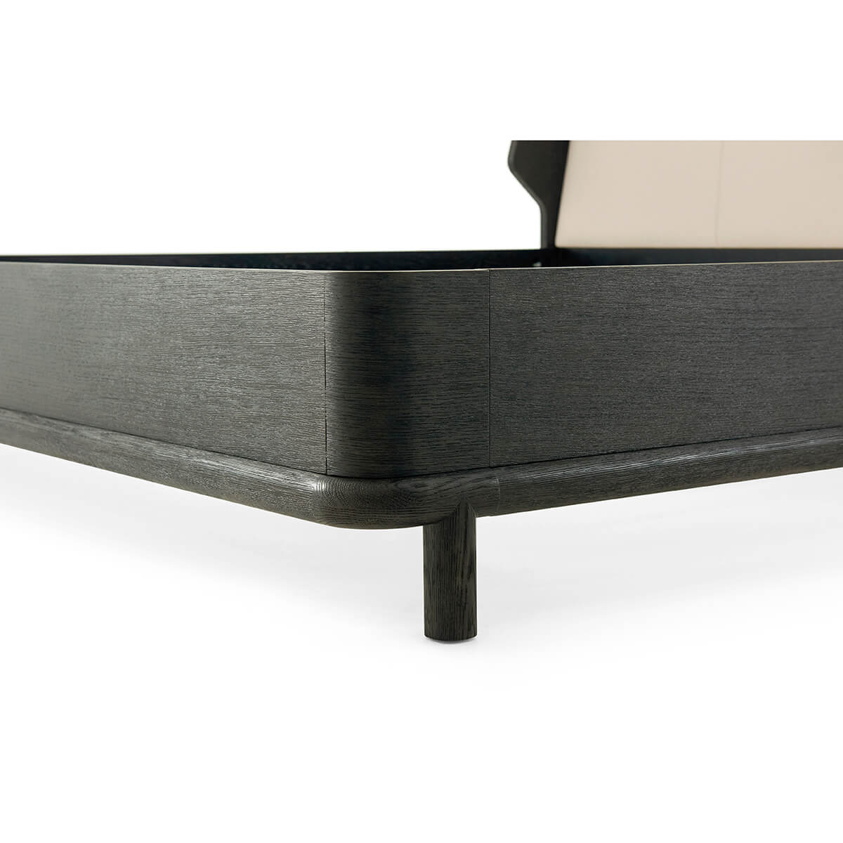 Corner detail of modern dark oak bed frame.