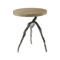 Modern accent table with round top and unique legs.