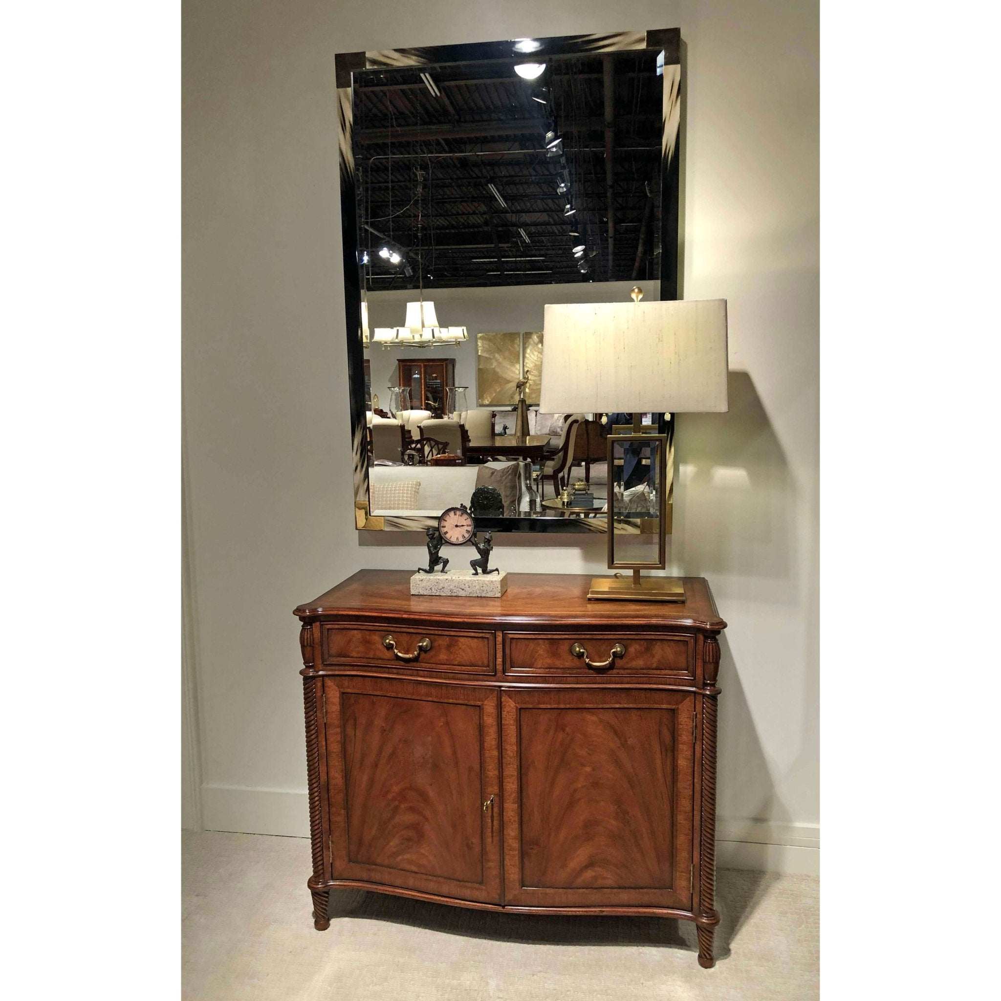 Modern faux horn mirror above wooden furniture, room setting.