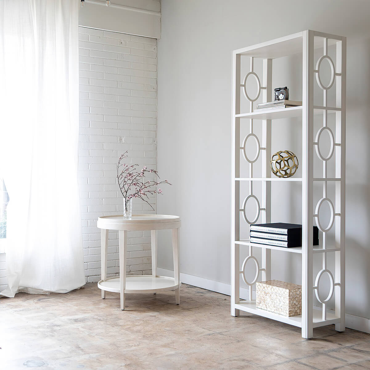 White etagere styled in room with decor items.
