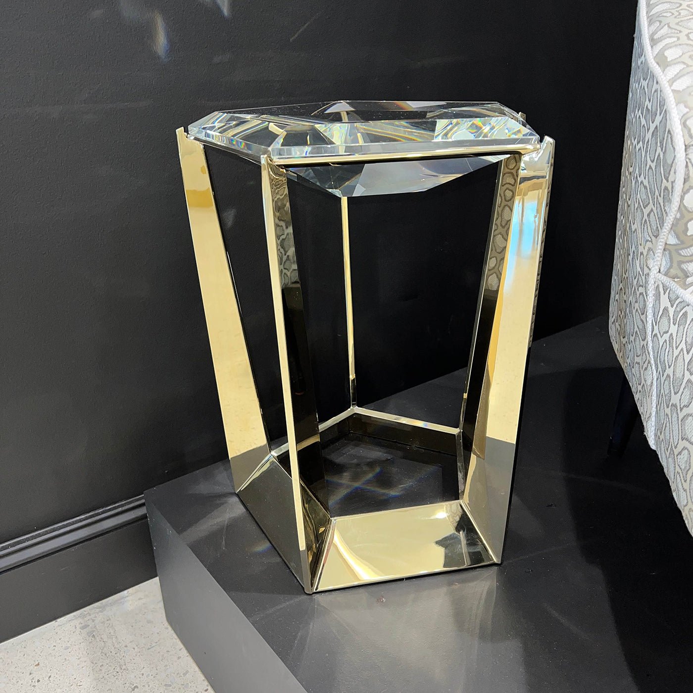 Side view of hexagonal gold and glass accent table.