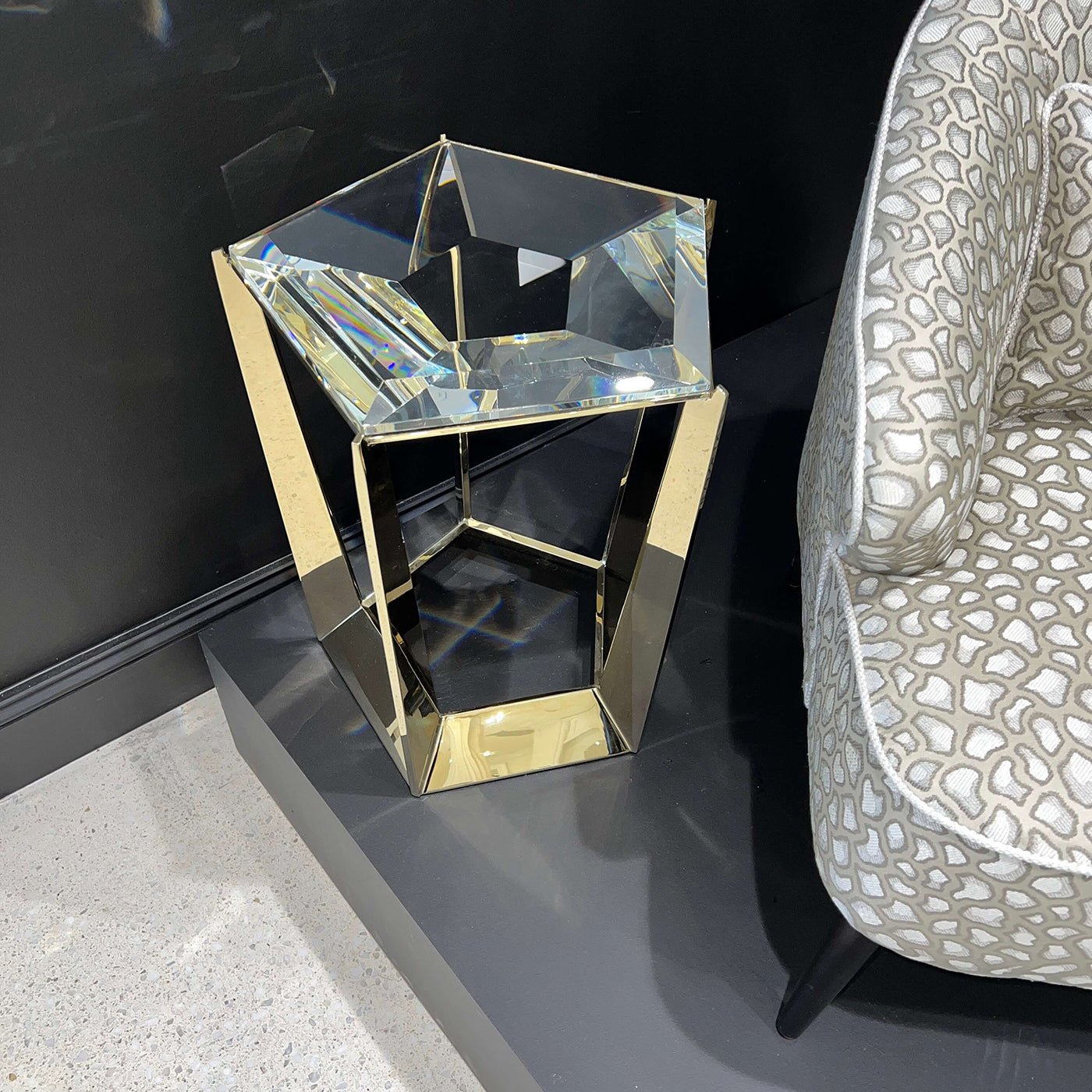 Top view of glass-hexagonal accent table next to chair.