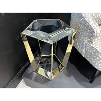 Gold frame accent table against a black wall.
