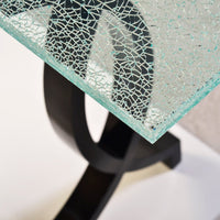 Close-up of cracked glass top on console table.