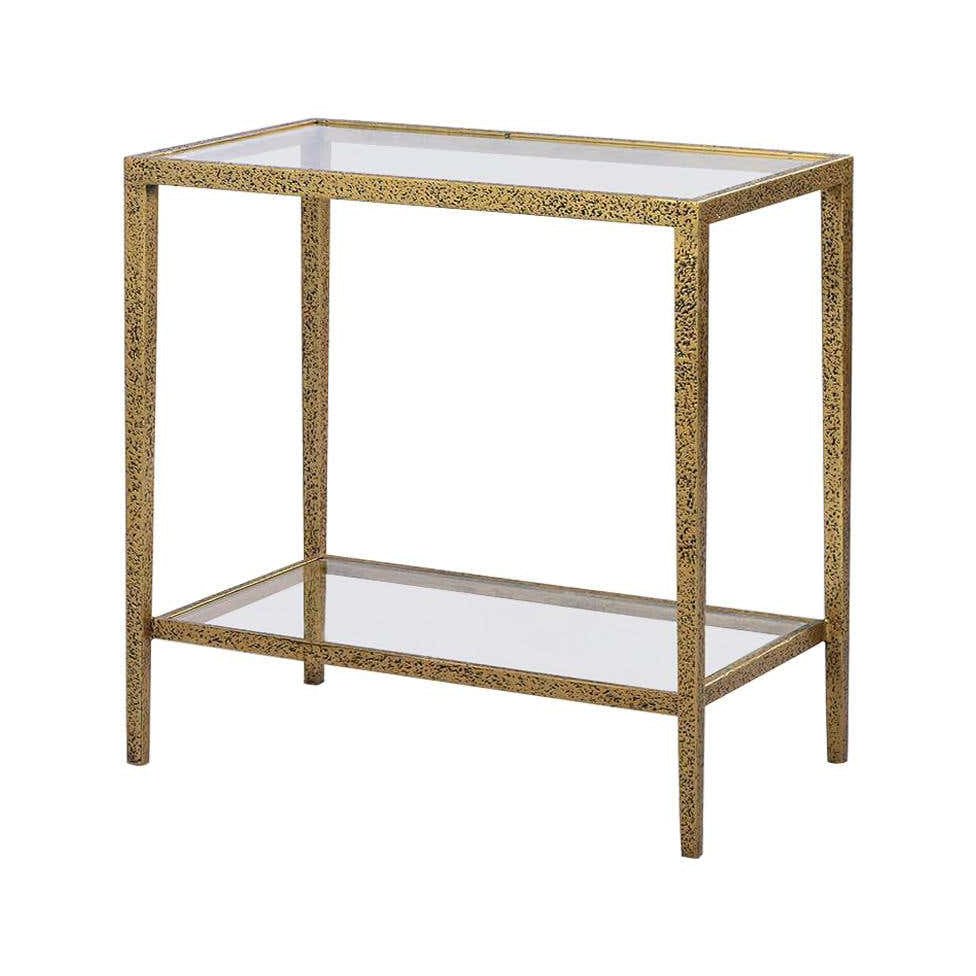 Rectangular side table with glass top and gold frame.